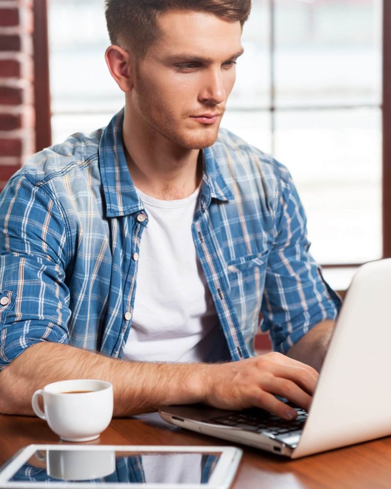 taking-advantages-of-free-wi-fi-handsome-young-man-working-on-laptop-while-sitting-at-the-table-1.jpg